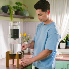 Man in a kitchen using a water filter